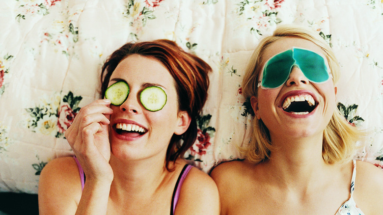 Two women laughing on a bed