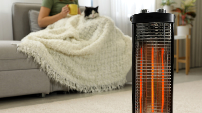 woman sitting next to a heater