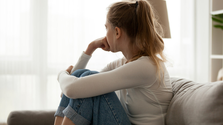 Depressed woman looking outside window