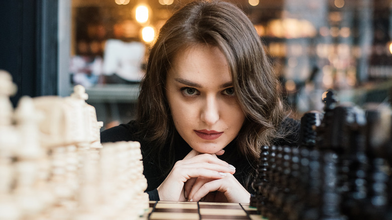 Woman staring over chessboard