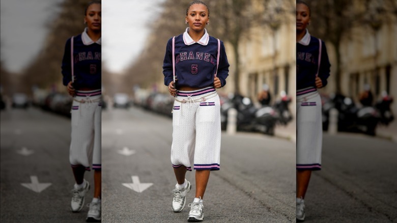 Woman in Chanel sweatshirt and cropped pants