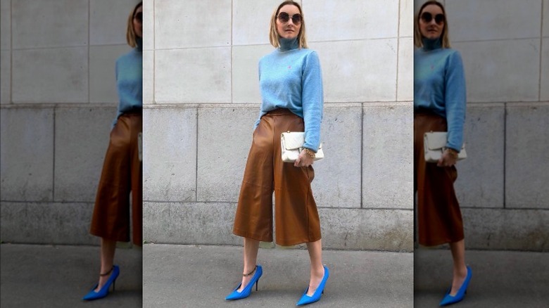 Woman in leather gaucho pants and blue sweater