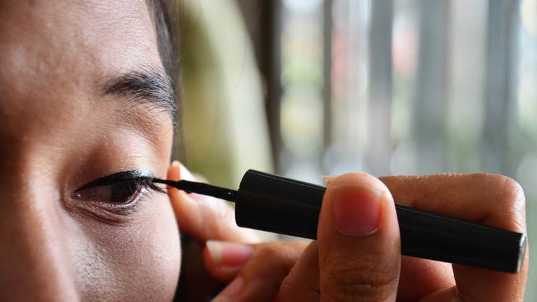 woman applying liquid liner