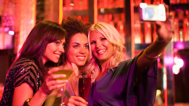 friends at bar taking selfie 