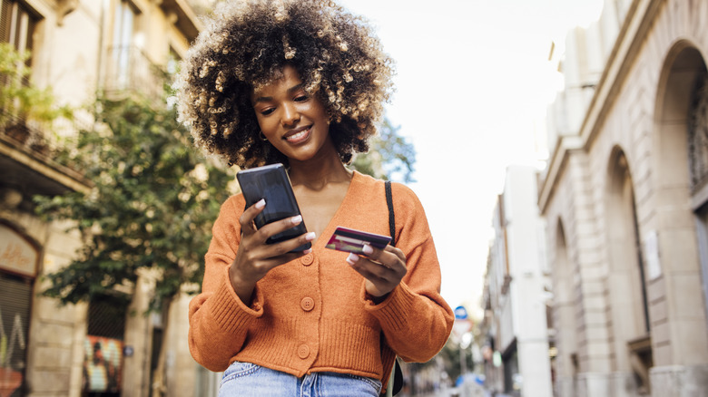 Woman shops on cell phone