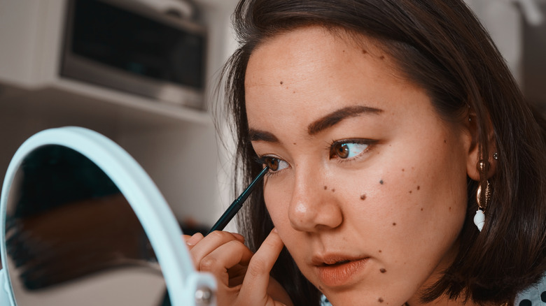 woman applying eye liner