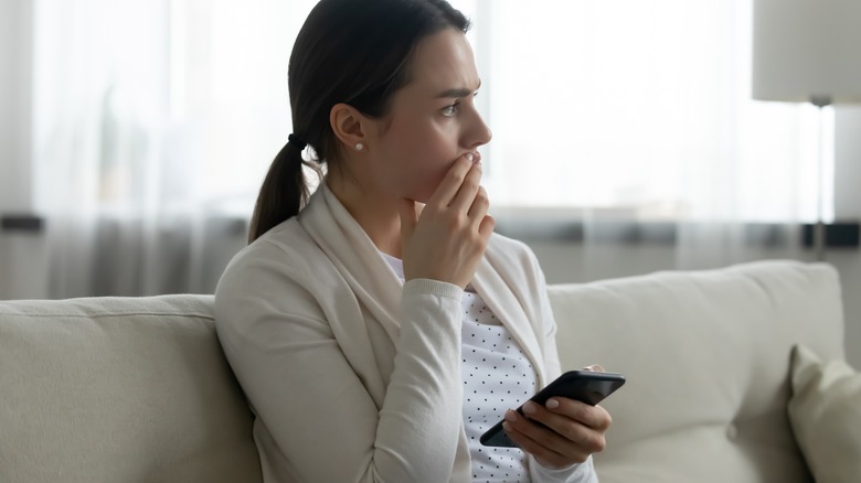 Woman looking stressed holding phone