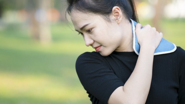 Woman applying cold compress neck