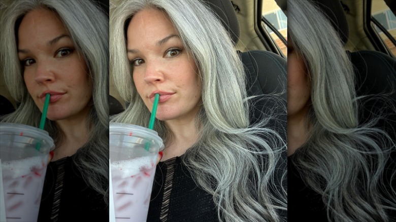 Woman with gray hair drinking beverage