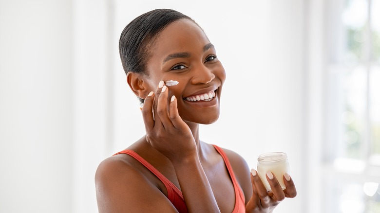 woman applying moisturizer