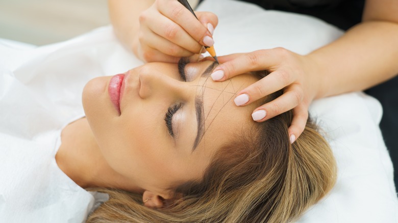 Girl getting permanent brow makeup.