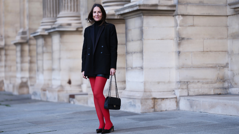 Woman wearing red tights, black mini skirt