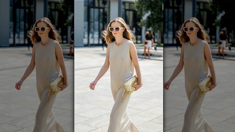 woman holding gold clutch