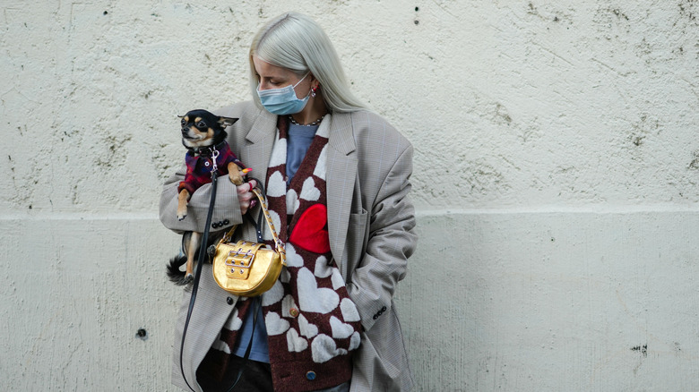 woman holding gold buckled bag