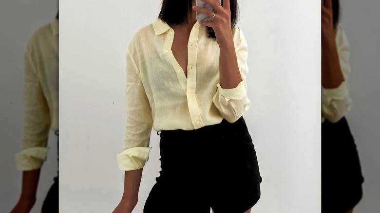 woman wearing a yellow linen shirt and black shorts