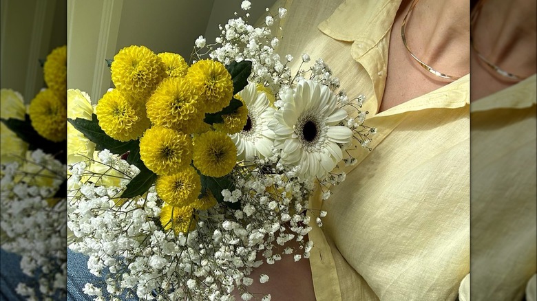 Woman wearing a yellow linen shirt and gold necklace