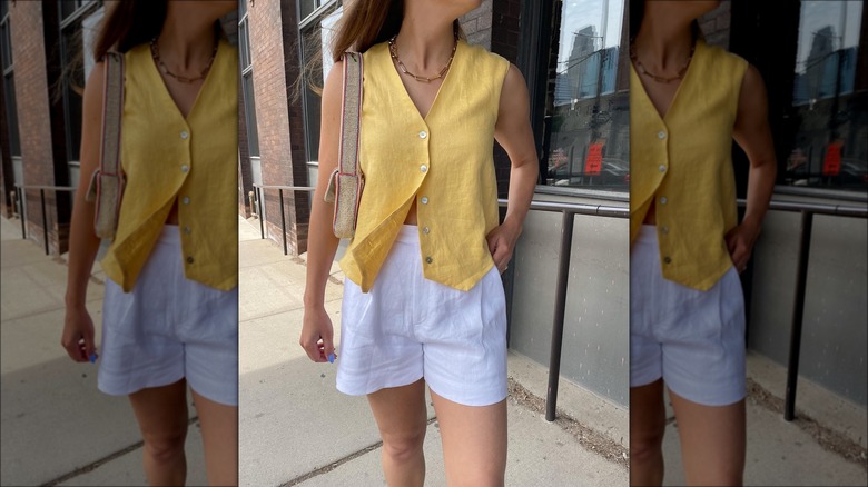 Woman wearing a gold linen vest and white shorts
