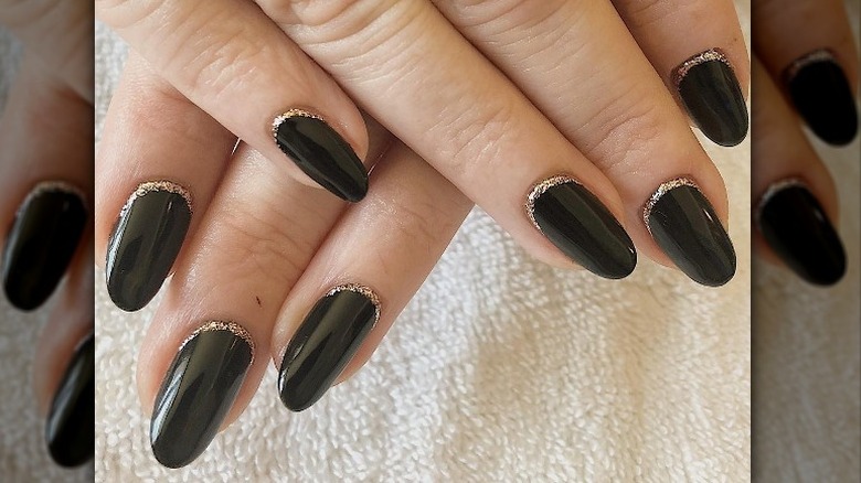 Instagram user @bluesy_nails showing black manicure and gold cuticle glitter