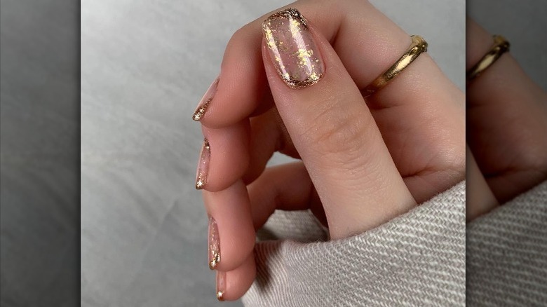 Instagram user @isabelmaynails showing nails with gold flakes 