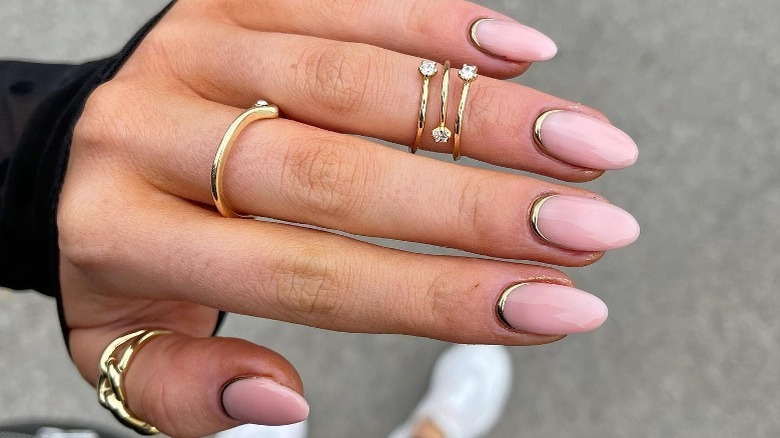 Instagram user @simplysophbeauty showing hand with gold gel cuticle manicure 