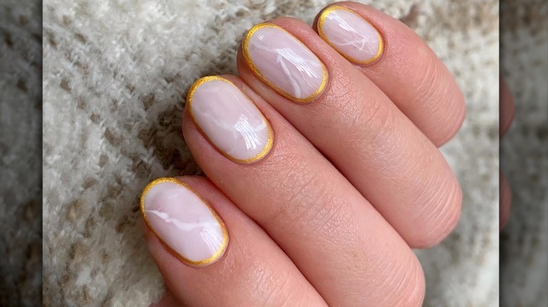 Instagram user @mariavinails showing matte gold outline manicure