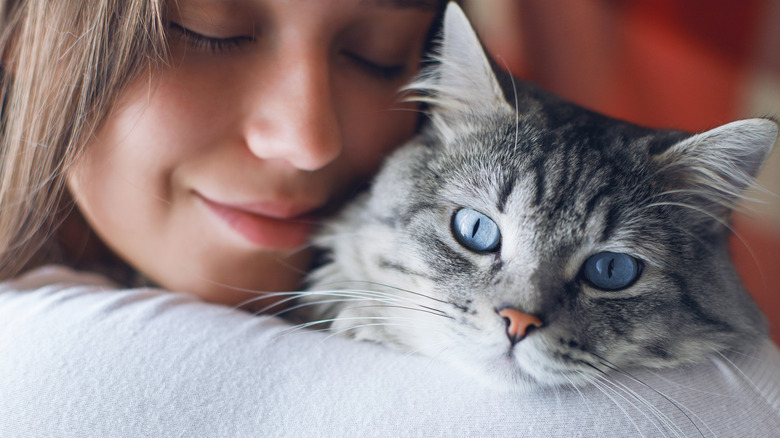 person happily embracing cat