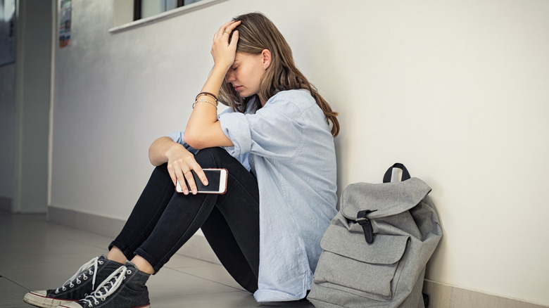 person sitting alone in hallway