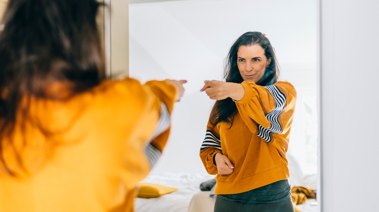 person pointing at self in mirror