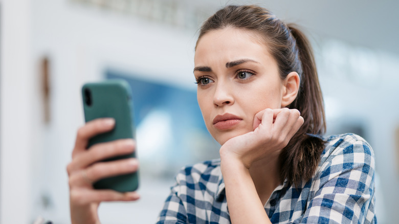 stressed woman looking at phone