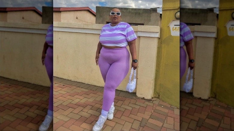 Woman poses in purple leggings 