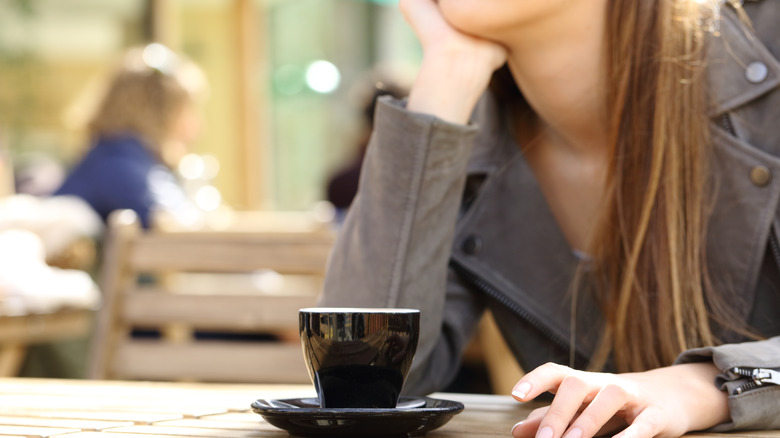 Woman waits with espresso