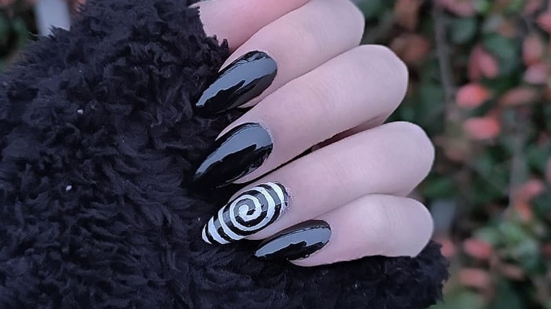 black manicure with black and white swirl accent nail