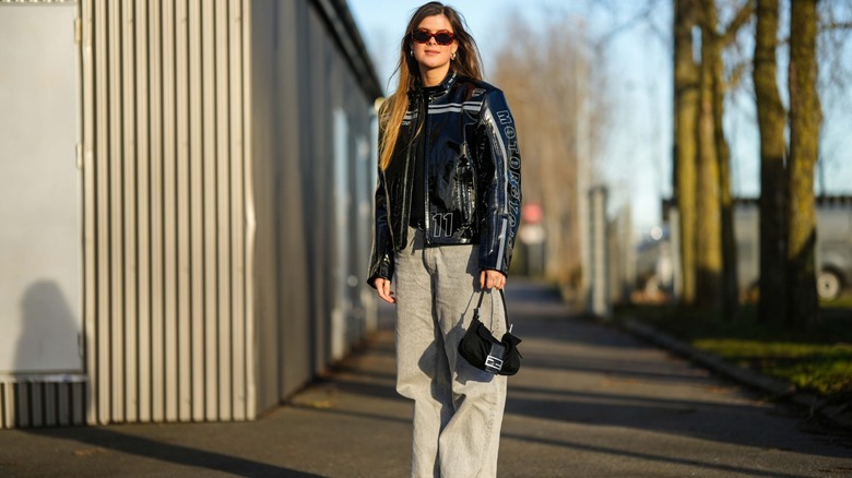 Woman wearing gray jeans, moto jacket