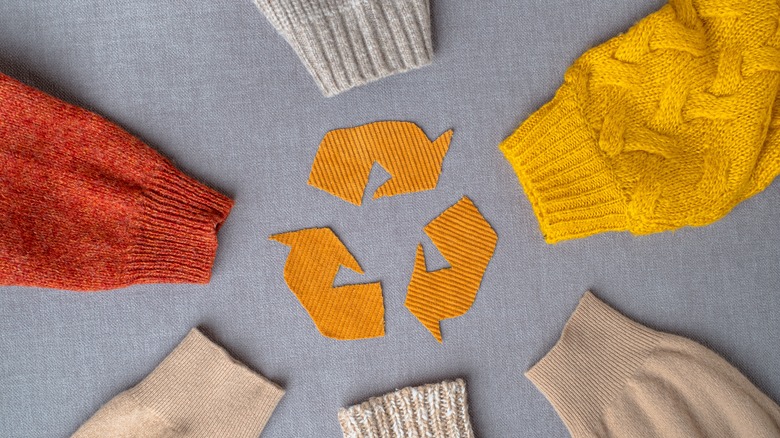 Sweater sleeves surrounding recycling symbol