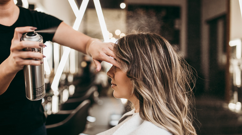 hairstylist spraying hairspray