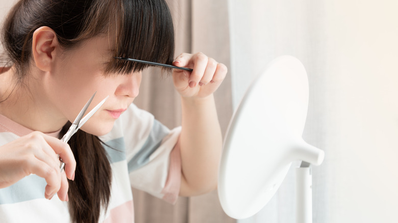 woman trimming bangs