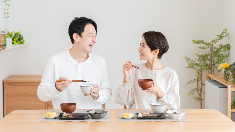 Happy couple talking eating 