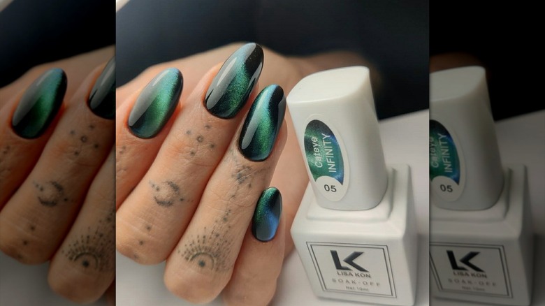 Hailey Bieber's green cat-eye manicure posed next to LK Infinity nail polish