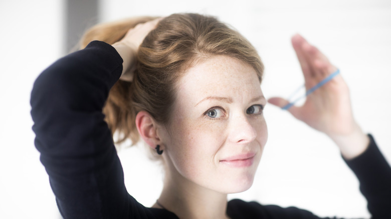 Woman tying hair with elastic