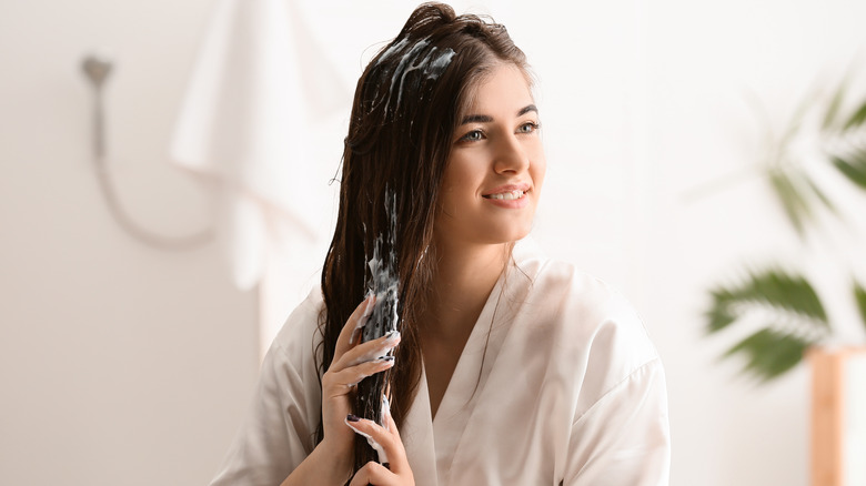 Woman applying product to hair