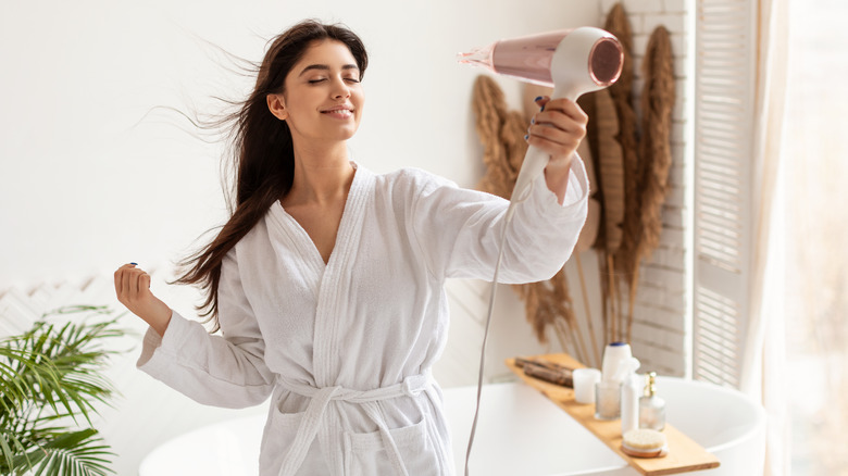 Woman blow-drying her hair 