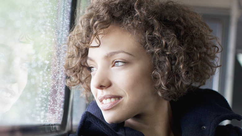 woman curly hair sitting train