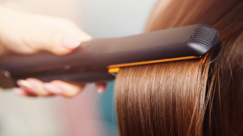 Woman using flat iron tool