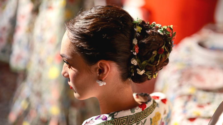 model side profile, showing flowers in hair