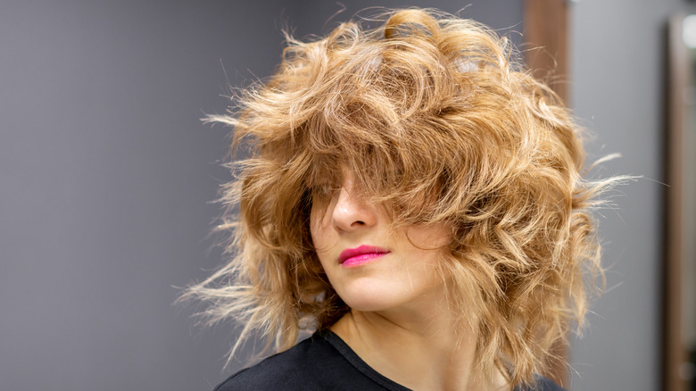 A person with wavy shag haircut and pink lips