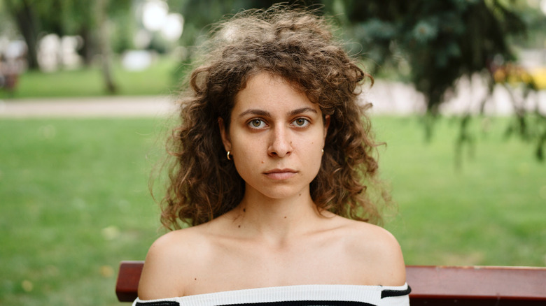 A woman with frizzy air-dried curly bangs