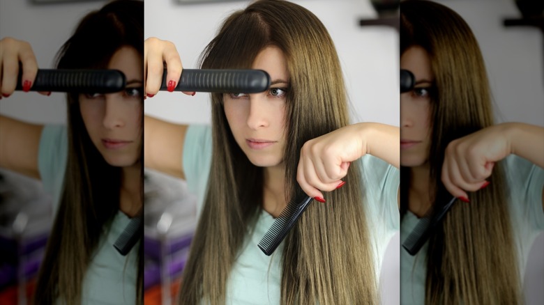 A woman flat ironing her straight brown bangs