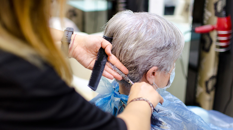 A hairstylist cutting a pixie