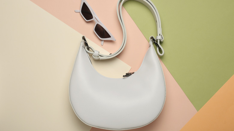 White crescent shape handbag with sunglasses