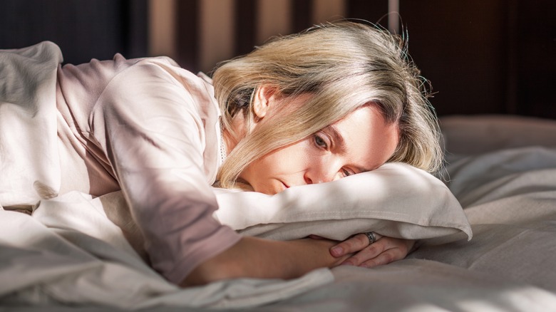 depressed woman laying in bed